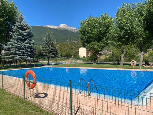 ein großer blauer Pool mit einem Berg im Hintergrund in der Unterkunft Rincon de Pepo in Villanúa
