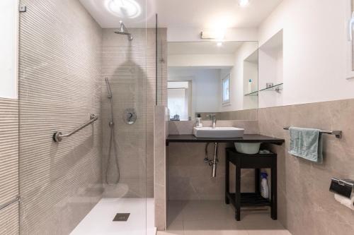 a bathroom with a shower and a sink and a mirror at Apartamento en centro de Bilbao, Deusto in Bilbao