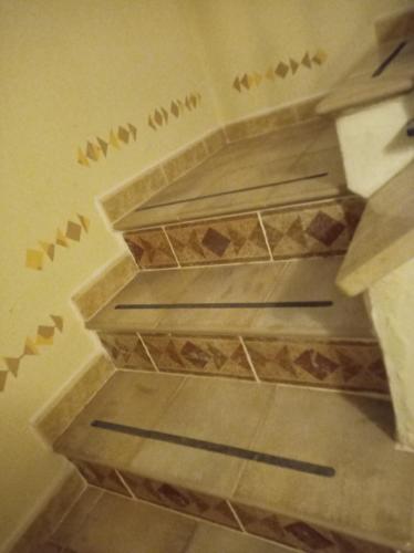 un escalier en colimaçon avec des oiseaux peints sur le mur dans l'établissement Casa Betti, à Palerme