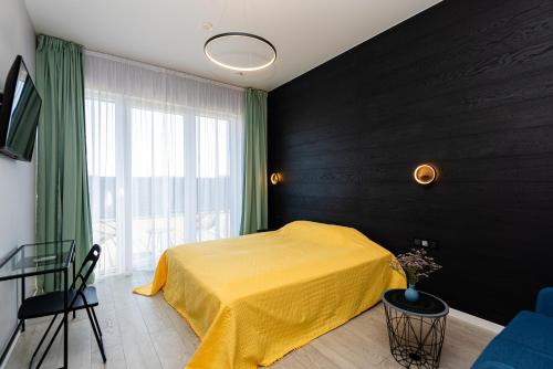 a bedroom with a yellow bed and a window at 2NIGHT in Šventoji in Palanga