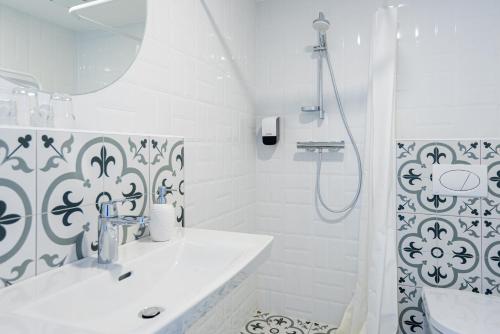 a white bathroom with a sink and a shower at 2NIGHT in Šventoji in Palanga