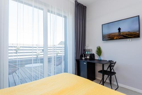 a bedroom with a bed and a television on a wall at 2NIGHT in Šventoji in Palanga