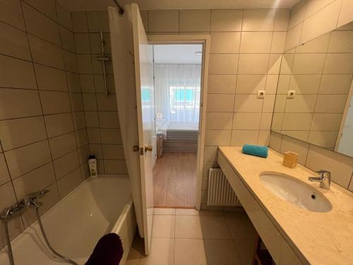 a bathroom with a tub and a sink and a shower at París Habitaciones in Barcelona