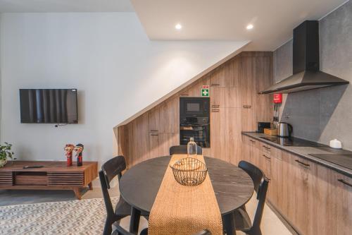 a kitchen with a table with chairs and a counter at Maria Veiga Guest House in Viana do Castelo