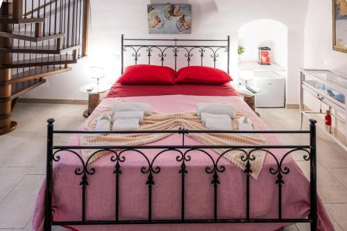 1 dormitorio con 1 cama grande con almohadas rojas en Il Borgo Antico B & B, en Capurso