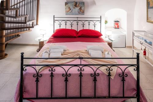 a bedroom with a large bed with red pillows at Il Borgo Antico B & B in Capurso