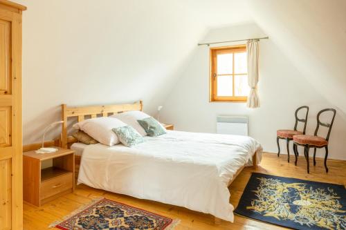 1 dormitorio con 1 cama con sábanas blancas y ventana en Dom w Jaśminach en Nałęczów