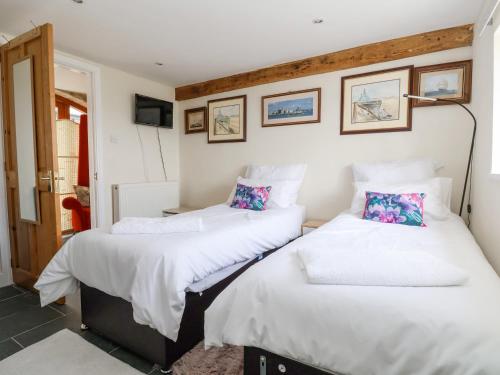 two twin beds in a room with a tv at Coach House in Ruthin