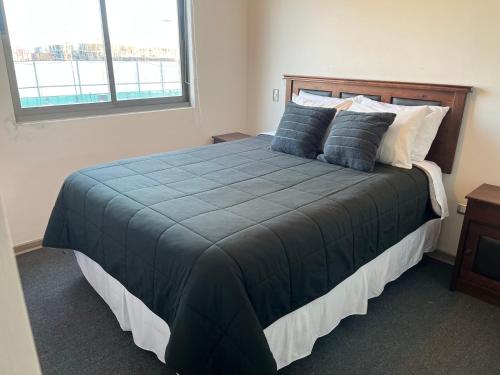 a bedroom with a large bed with a blue comforter at Departamento full equipamiento in San Pedro de la Paz