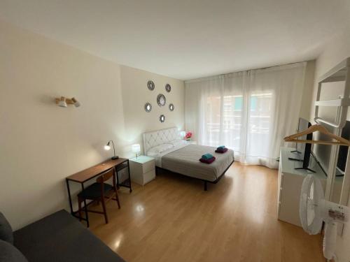 a small bedroom with a bed and a desk and a table at París Habitaciones in Barcelona