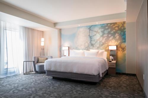 a hotel room with a bed and a chair at Courtyard by Marriott Ciudad Juarez in Ciudad Juárez