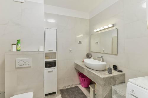 a white bathroom with a sink and a mirror at LUXURY MARIJANA APARTMENT in Privlaka