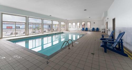 una gran piscina con sillas azules en un edificio en Prestige Rocky Mountain Resort Cranbrook, WorldHotels Crafted, en Cranbrook