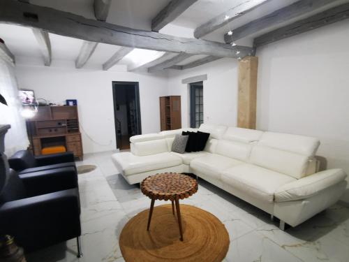 uma sala de estar com um sofá branco e uma mesa em Maison côté jardin em Sevran