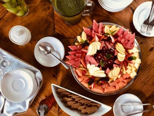 una mesa de madera con un plato de ensalada de frutas en Hacienda Shambalante, en Izamal