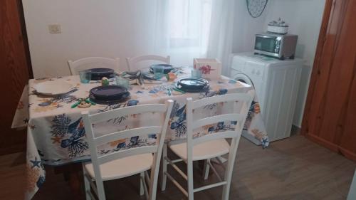 mesa de comedor con sillas y mantel en Domo Mea, en Miniera dellʼArgentiera