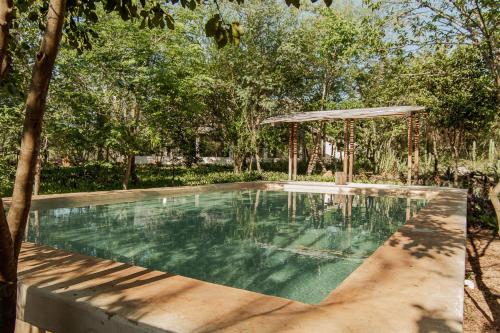 uma piscina com um gazebo em Hacienda Shambalante em Izamal