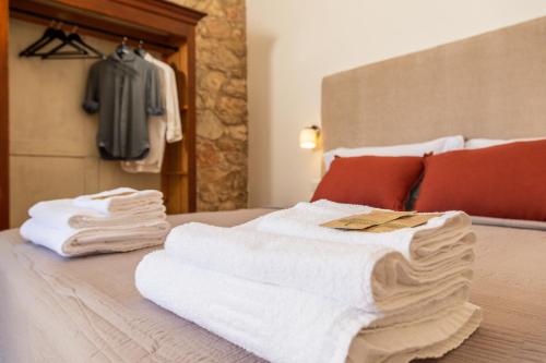 a pile of towels sitting on top of a bed at Monte Forru in Baunei