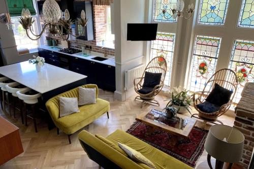 a living room with a table and chairs and stained glass windows at Stunning 3 bedroom Victorian home near Pollok country park in Glasgow
