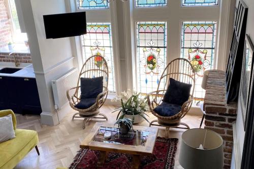 a living room with chairs and stained glass windows at Stunning 3 bedroom Victorian home near Pollok country park in Glasgow