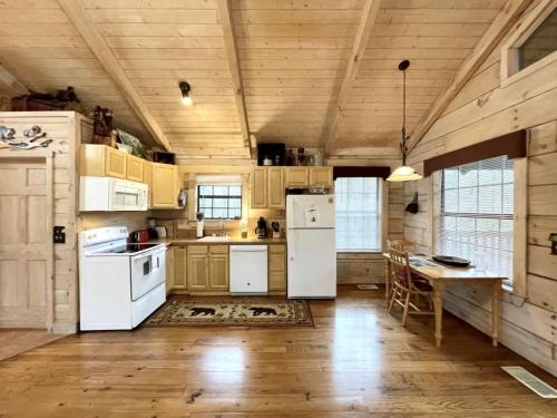 cocina con electrodomésticos blancos y techo de madera en Crazy Bear - Motorcycle Friendly Home with Hot Tub and Grill, en Tellico Plains