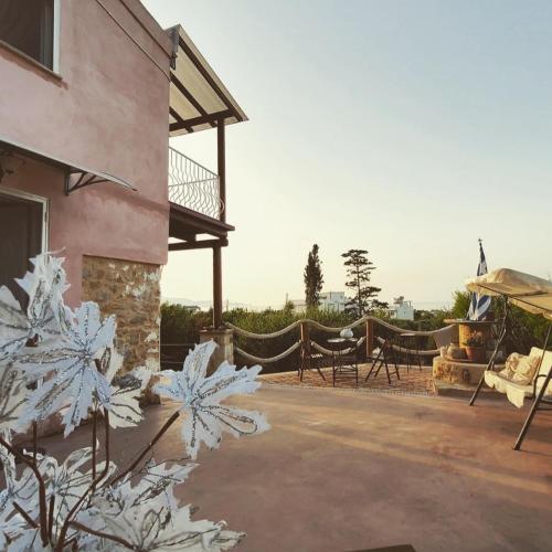 a house with white flowers in front of a building at Momentum Θ in Maleme