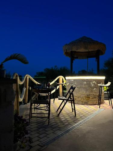 a patio with chairs and a gazebo at night at Momentum Θ in Maleme