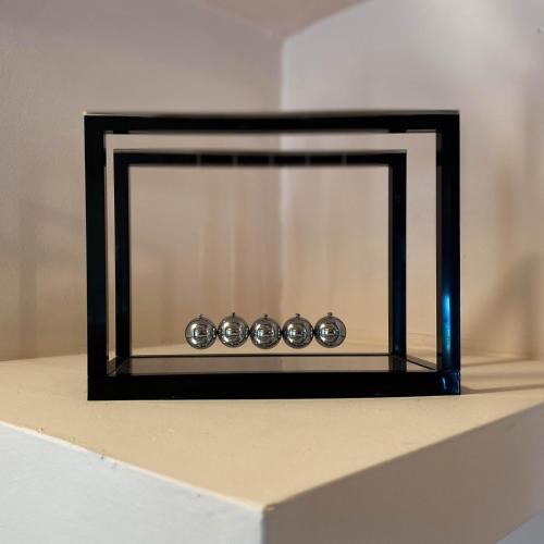 a mirror with four clocks sitting on top of a table at Momentum Θ in Maleme