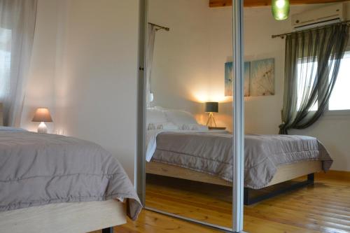 a bedroom with two beds and a mirror at Momentum Θ in Maleme