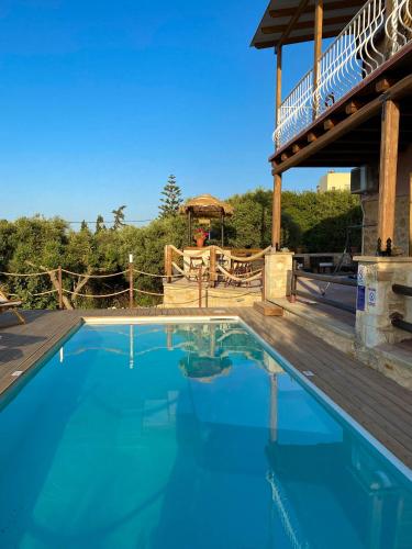 a large blue swimming pool with a wooden deck at Momentum Θ in Maleme