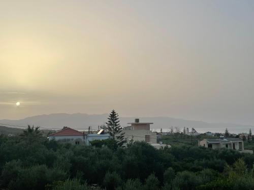 a group of houses on a hill with the sunset at Momentum Θ in Maleme