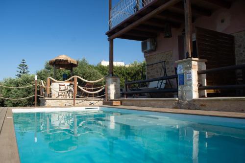 a large blue swimming pool in front of a house at Momentum Θ in Maleme