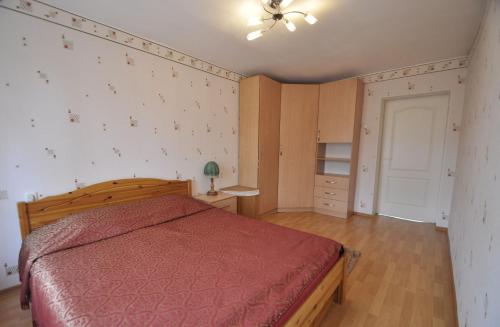 a bedroom with a bed with a red bedspread at Bastrakovi Apartment in Narva