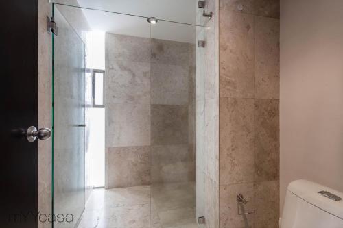 y baño con ducha y puerta de cristal. en Destination Condesa @Tamaulipas Loft, en Ciudad de México