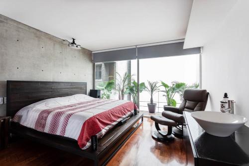 1 dormitorio con 1 cama, lavamanos y silla en Destination Condesa @Tamaulipas Loft, en Ciudad de México