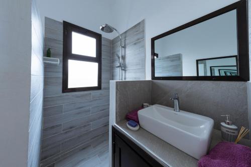 a bathroom with a sink and a mirror at ChezBabo Wellness Hotel in Ngaparou