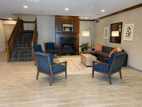 a living room with two chairs and a couch at Country Inn & Suites by Radisson, Champaign North, IL in Champaign