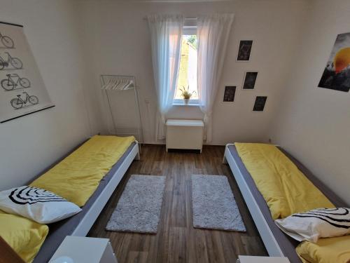 two beds in a room with a window at Ferienhaus Jena - Teamwork Holiday House 