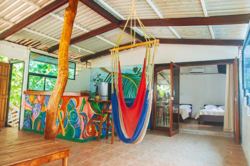 a room with two hammocks hanging from the ceiling at Arrecife Punta Uva - Hospedaje, bar y restaurante - Frente al mar in Punta Uva