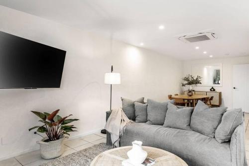 a living room with a couch and a table at Beachside Serenity in Byron Bay