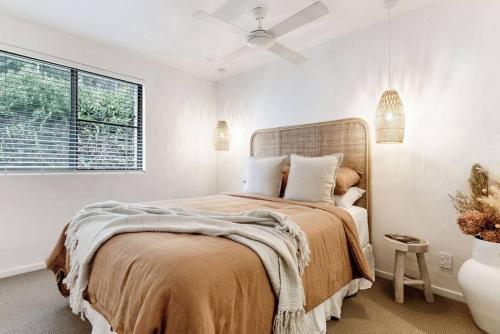 een slaapkamer met een bed en een raam bij Beachside Serenity in Byron Bay