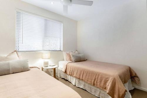 a bedroom with two beds and a window at Beachside Serenity in Byron Bay