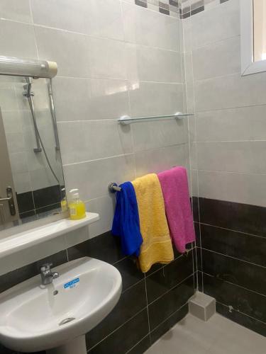 La salle de bains est pourvue d'un lavabo, d'un miroir et de serviettes. dans l'établissement Appartement neuf meublé dans le Centre d'Agadir, à Agadir
