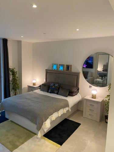 um quarto com uma cama grande e um espelho em Ardwyn Studio Apartments Gibraltar em Gibraltar