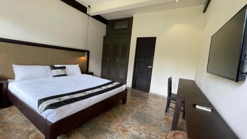 a bedroom with a bed and a flat screen tv at Ariella Mangrove & Eco Resort by Hiverooms 