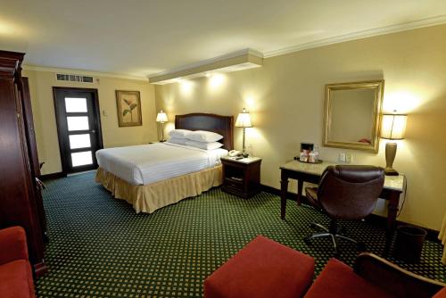 ein Hotelzimmer mit einem Bett und einem Stuhl in der Unterkunft Marriott Torreon Hotel in Torreón