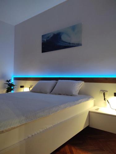 - une chambre dotée d'un lit avec des lumières bleues dans l'établissement Apartman Wolf, à Varaždin