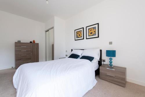 倫敦的住宿－Luxury Apartment Canning Town，白色卧室设有一张大床和一个梳妆台