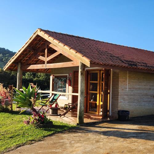 a small house with a wooden roof at Pousada Vale Monte Azul in Santo Antônio do Pinhal