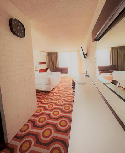 a hotel room with a bed and a clock on the wall at Indian Ocean Hotel in Perth